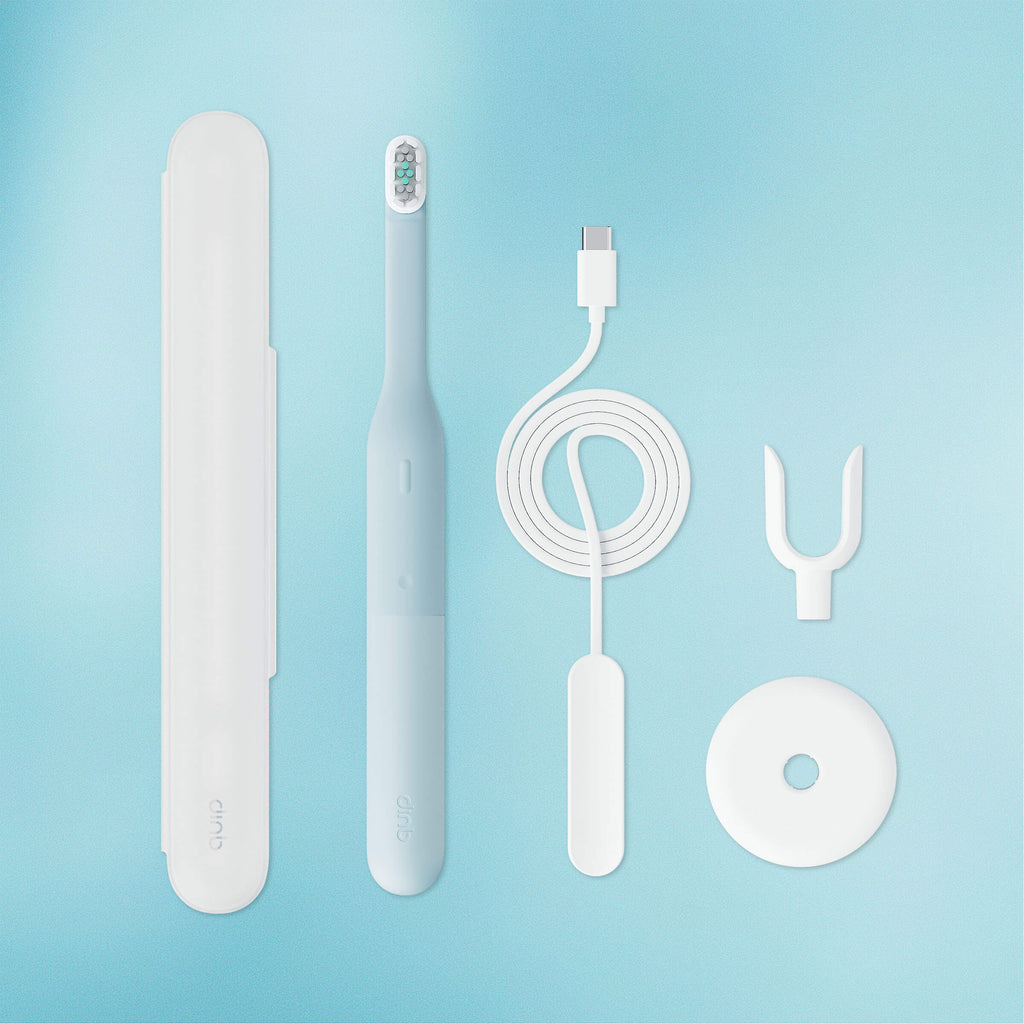 Set of dental care products including a toothbrush, charger, and cleaning tools on a light blue background.