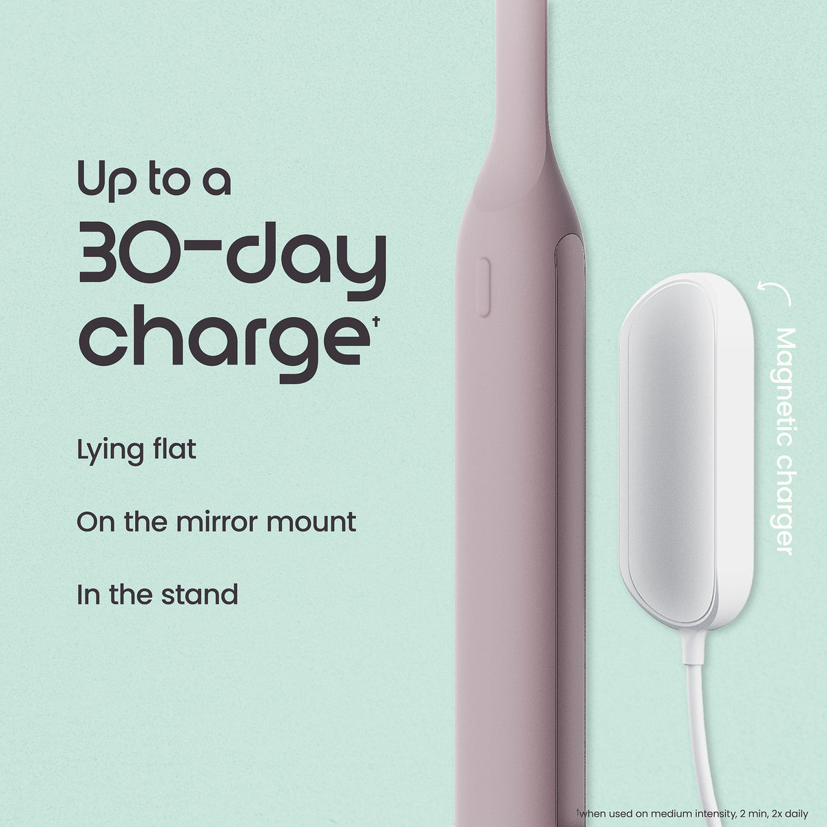Pink electric toothbrush with charging stand on a light green background