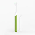 A kids sonic toothbrush with a green handle and white body, alongside a travel cover or mount.
